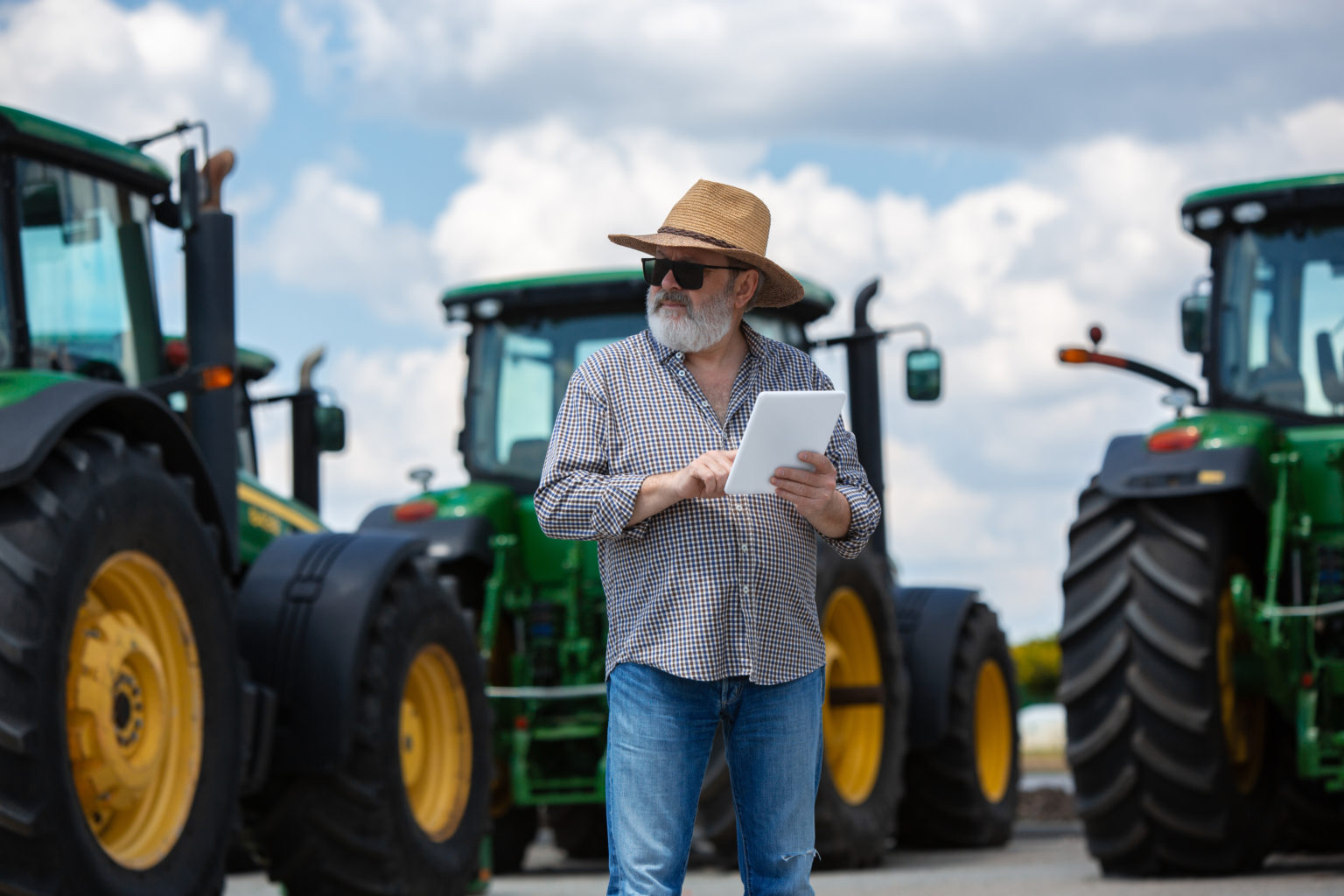 A farmer with a tractor, combine at a field in sunlight. Confident, bright colors